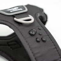 Close-up of the waterproof feature on a black dog harness, with padded, adjustable design and top handle for comfort and control.